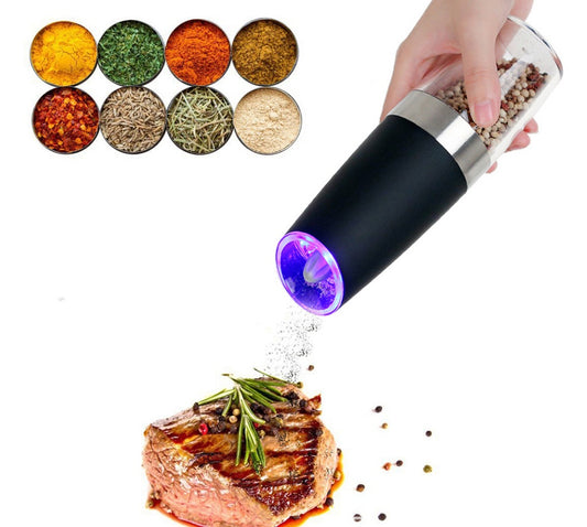 Pepper grinder being used to season a steak with various colored pepper options displayed above.