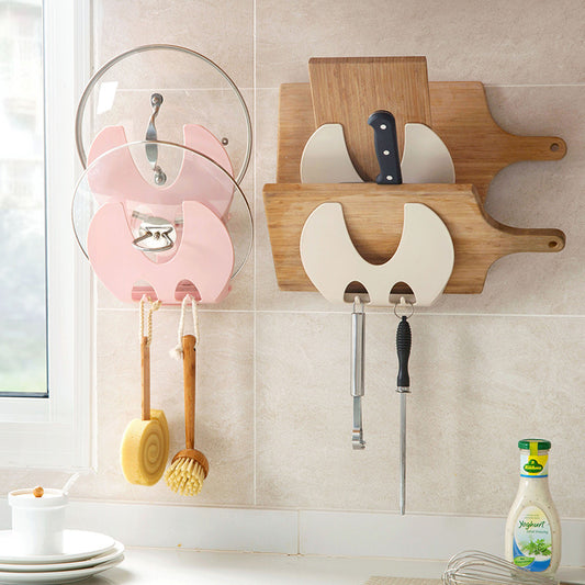 Wall-mounted kitchen organizer with cutting boards, knives, and utensils on a tiled wall.