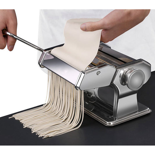 Pasta maker making pasta on a black surface with a white background
